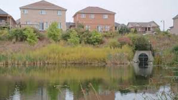 photo of two houses, and a stormwater outfall draining into Lake Simcoe in Ontario, Canada | credit Lake Simcoe Region Conservation Authority (LSRCA)