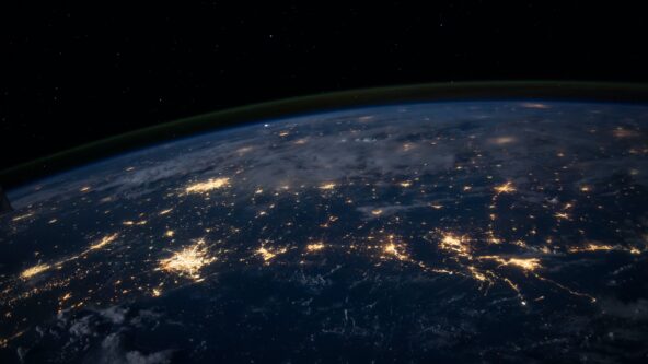 image photo of earth taken from space; urban areas represented by clusters of light against a dark sky