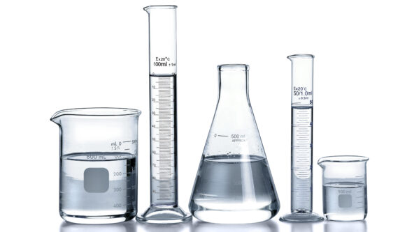 photo of various analytical laboratory glassware containing water quality samples; reflective surface and white background reveal water color