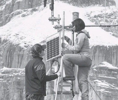 black and white photo University of Saskatchewan hydrology technicians perform maintenance on a weather station used to collect data to predict floods and droughts | source USASK.ca