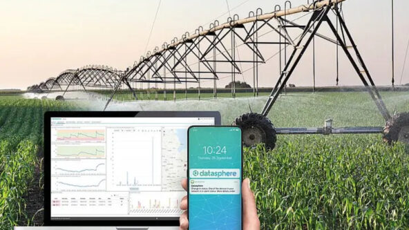 screen capture of datasphere agricultural irrigation monitoring software / application on a laptop and a smart phone with photo of a farm field irrigation system in the background