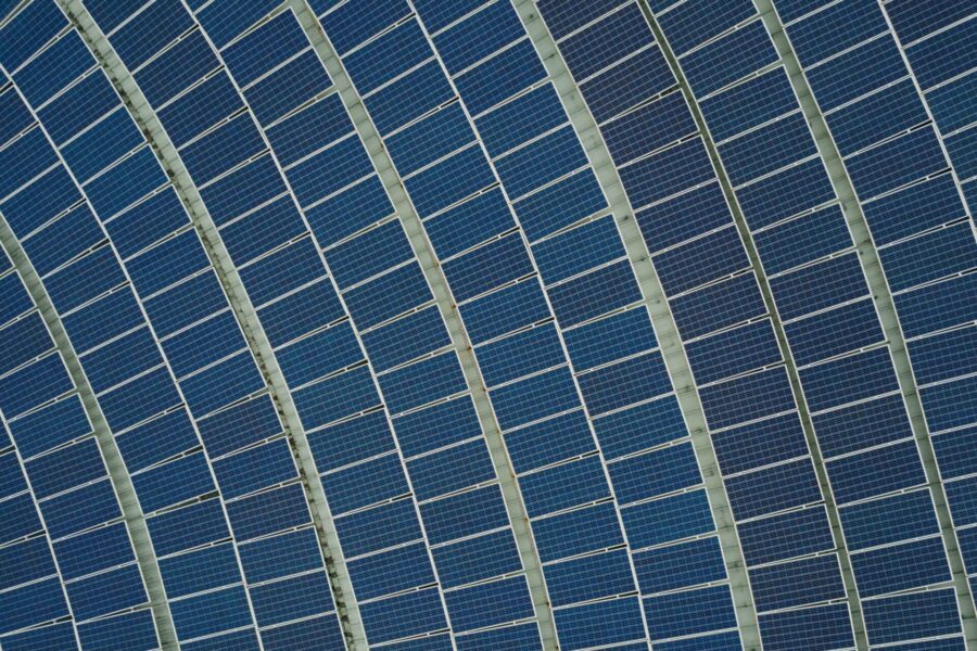 aerial photo of rows and rows of solar PV panels in a curved pattern | source chuttersnap via unsplash