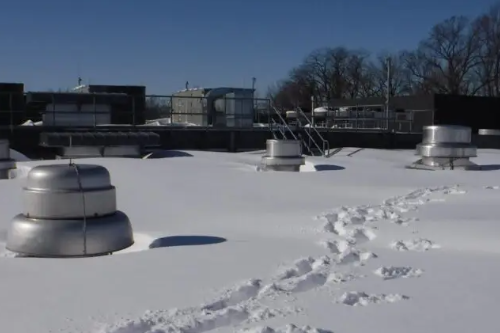 Several inches of snow accumulated on flat commercial roof.